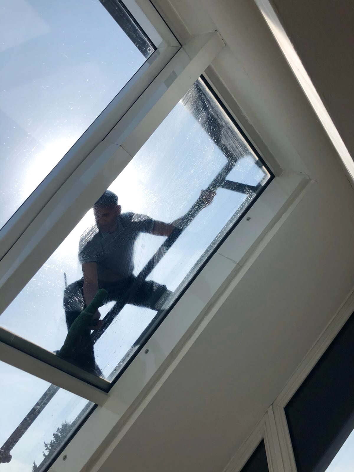 Fensterputzer reinigt ein Dachfenster von außen